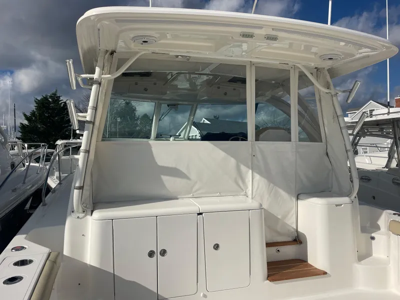 Slide: The Image of 2020 Pursuit 385 Offshore boat, white exterior, docked under cloudy sky. - 17