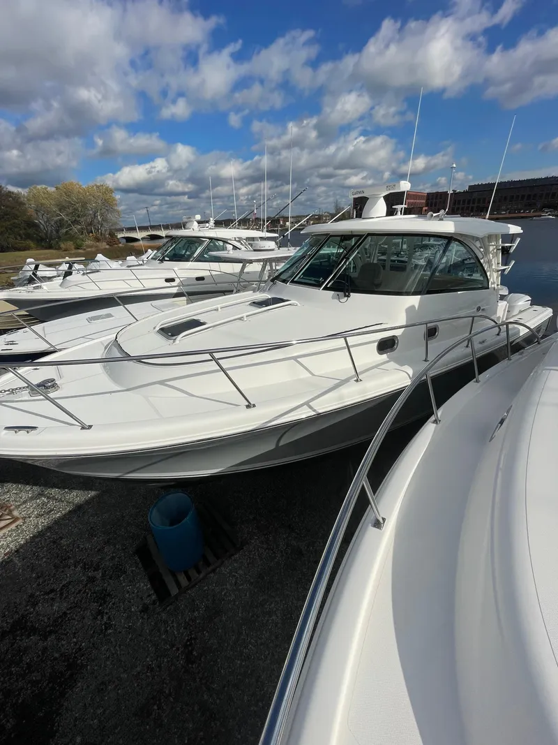 Slide: The Image of 2020 Pursuit 385 Offshore boat docked under a cloudy sky. - 18