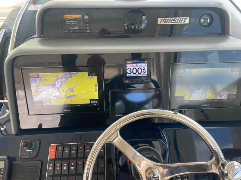 Slide: The Image of 2020 Pursuit 385 Offshore boat dashboard with navigation screens and controls. - 21