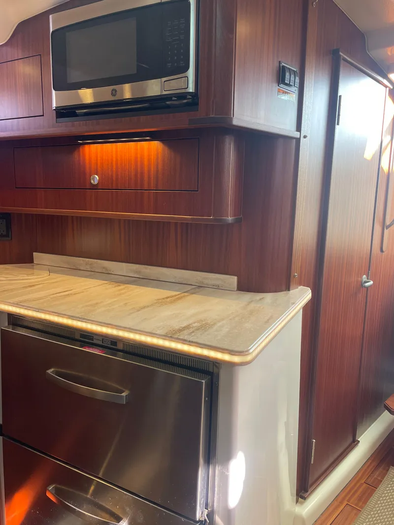 Slide: The Image of 2020 Pursuit 385 Offshore yacht kitchen with microwave and stainless steel appliances. - 26