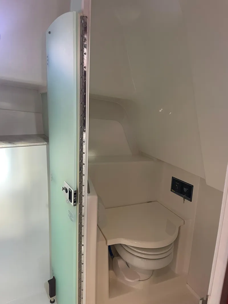 Slide: The Image of 2020 Pursuit 385 Offshore boat bathroom interior with compact toilet. - 34