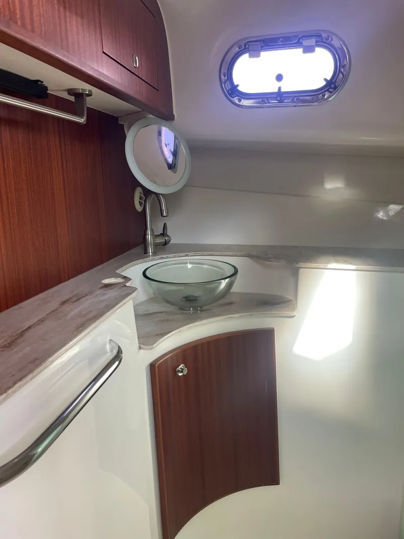 Slide: The Image of 2020 Pursuit 385 Offshore boat interior with wooden cabinetry and glass sink. - 35