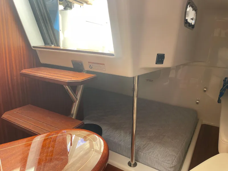 Slide: The Image of 2020 Pursuit 385 Offshore cabin interior with wooden steps and cozy sleeping area. - 36