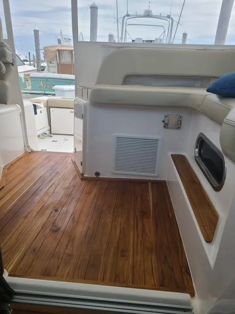Slide: The Image of 2020 Pursuit 385 Offshore boat interior with wooden flooring and cushioned seating. - 37