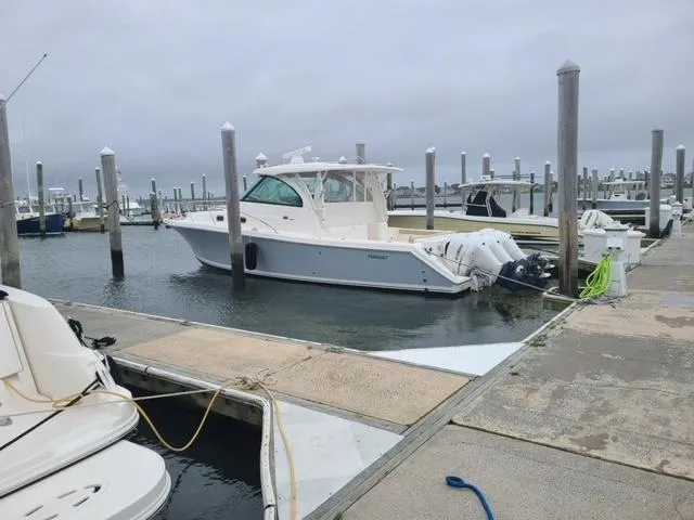 Slide: The Image of 2020 Pursuit 385 Offshore boat docked at marina on a cloudy day. - 4