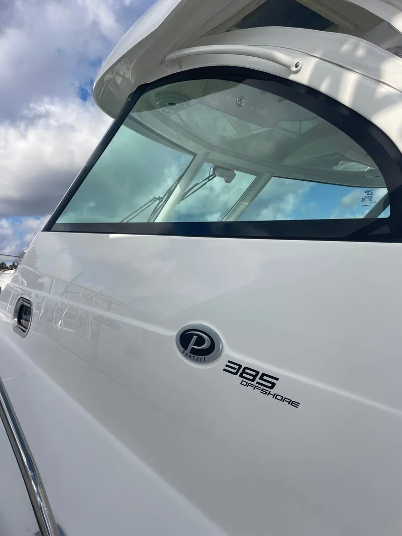Slide: The Image of 2020 Pursuit 385 Offshore boat, sleek design, close-up view under cloudy sky. - 6