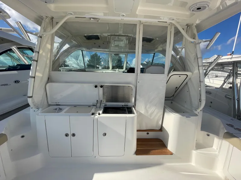 Slide: The Image of 2020 Pursuit 385 Offshore boat interior with kitchenette and seating area. - 8