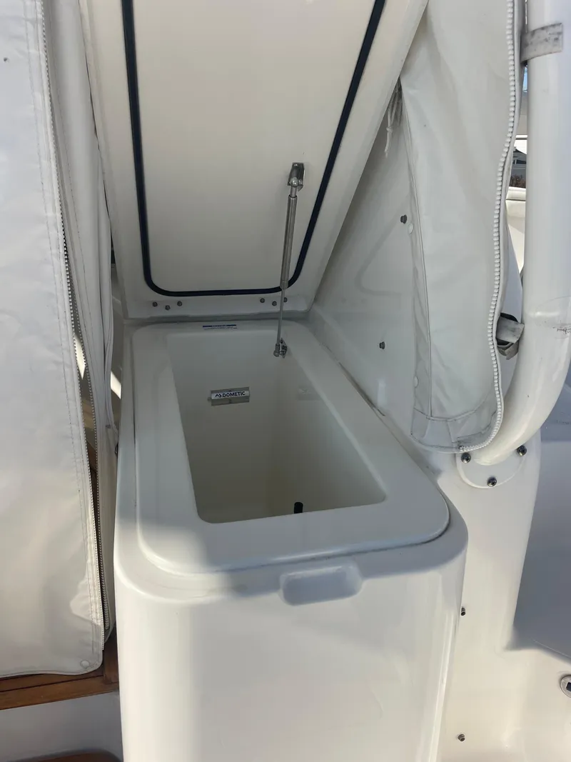 Slide: The Image of 2020 Pursuit 385 Offshore boat storage compartment with open lid. - 9
