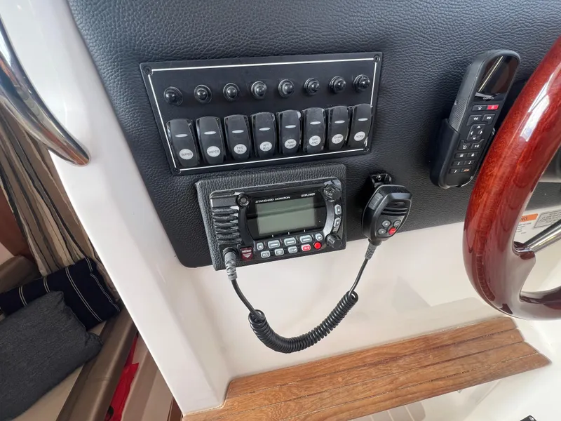 Slide: The Image of Control panel of 2021 Cutwater C28 boat with radio and switches. - 16