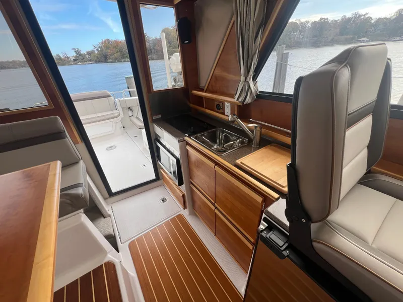 Slide: The Image of Interior of 2021 Cutwater C28 boat with kitchenette and seating, overlooking water. - 19