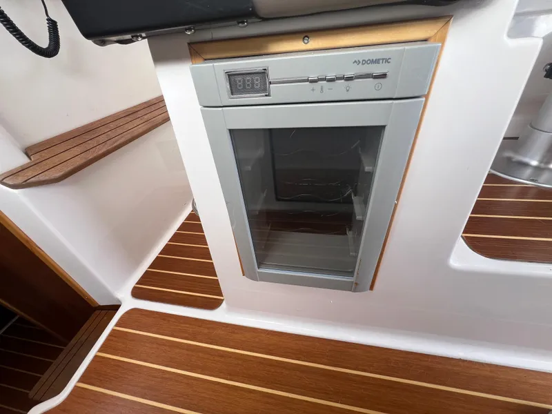 Slide: The Image of Dometic fridge in 2021 Cutwater C28 boat interior with wood flooring. - 23