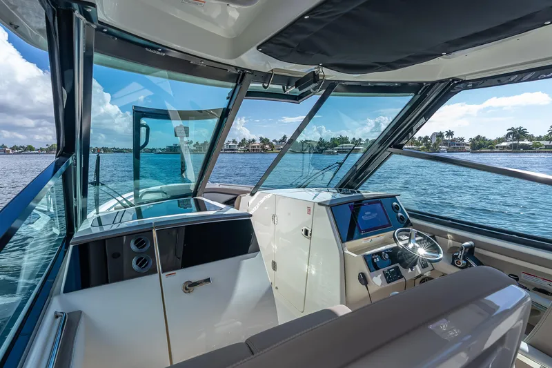 Slide: The Image of Interior view of 2025 Boston Whaler 330 Vantage boat cockpit with scenic water backdrop. - 15
