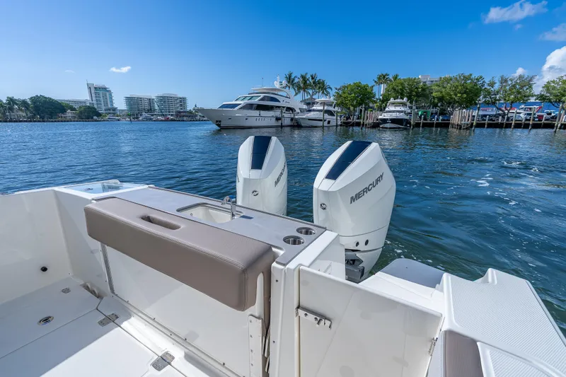 Slide: The Image of 2025 Boston Whaler 330 Vantage boat with Mercury engines docked in a marina. - 19