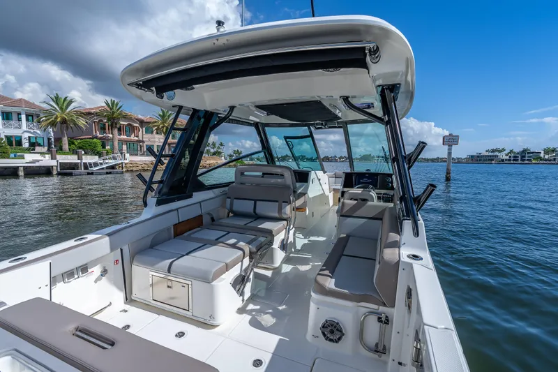 Slide: The Image of 2025 Boston Whaler 330 Vantage boat interior, docked by waterfront homes under a blue sky. - 21