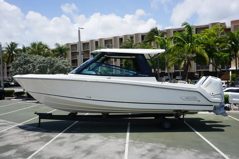 Slide: The Image of 2025 Boston Whaler 330 Vantage boat parked outdoors, surrounded by palm trees. - 23