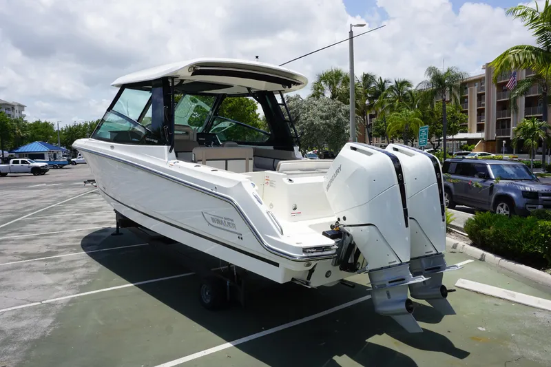 Slide: The Image of 2025 Boston Whaler 330 Vantage boat with dual engines, parked outdoors on a sunny day. - 24