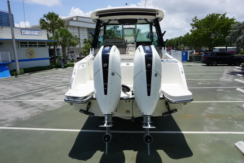 Slide: The Image of 2025 Boston Whaler 330 Vantage with dual engines in a parking lot. - 25