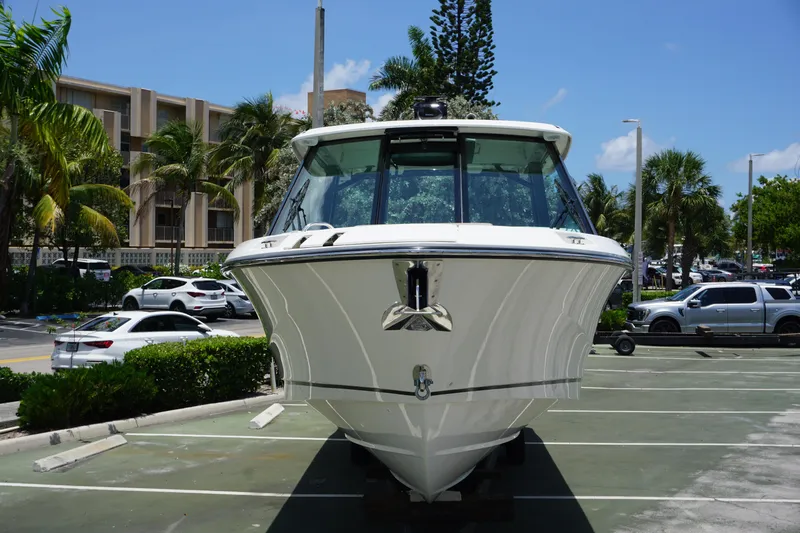 Slide: The Image of 2025 Boston Whaler 330 Vantage boat parked, surrounded by palm trees and vehicles. - 28