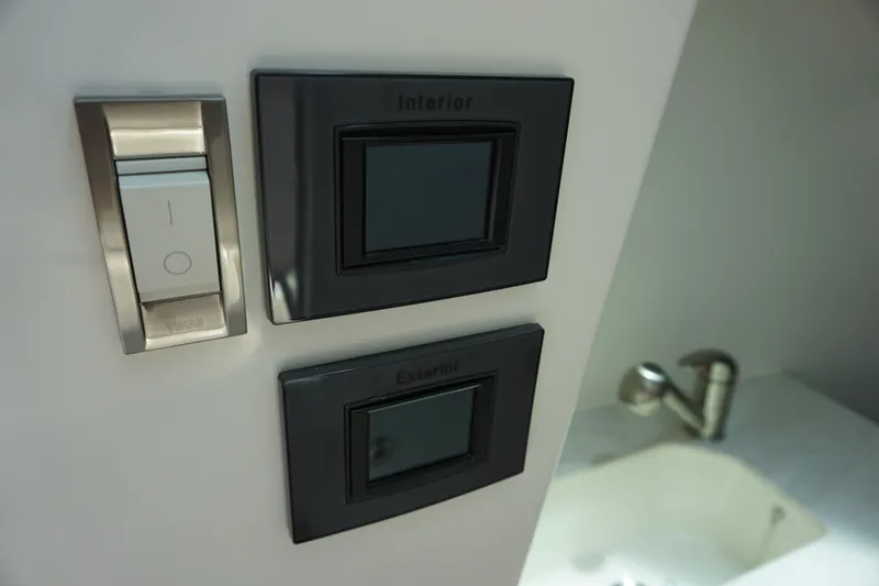 Slide: The Image of Interior controls on 2025 Boston Whaler 330 Vantage boat, featuring switches and a faucet. - 56