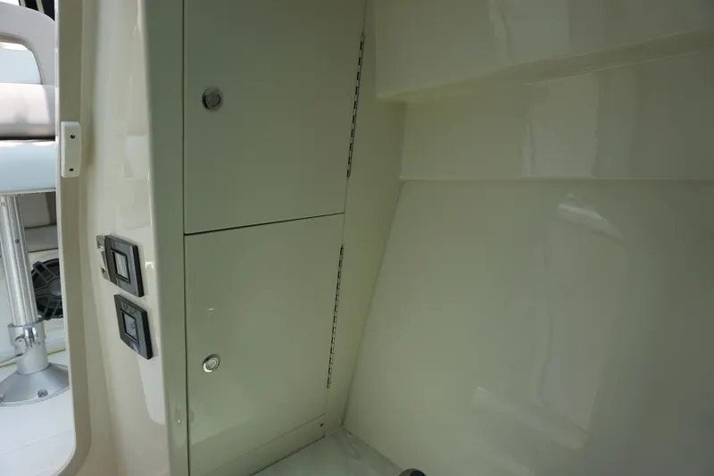 Slide: The Image of Interior view of 2025 Boston Whaler 330 Vantage boat, featuring storage compartments and control switches. - 57