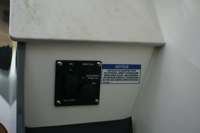 Slide: The Image of Control panel on 2025 Boston Whaler 330 Vantage with discharge pump and notice label. - 60