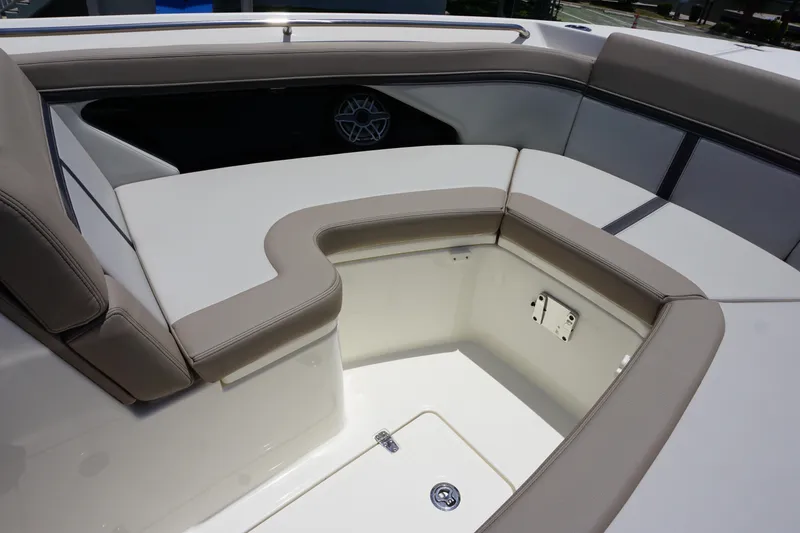 Slide: The Image of 2025 Boston Whaler 330 Vantage boat seating area with beige cushions and storage compartment. - 64