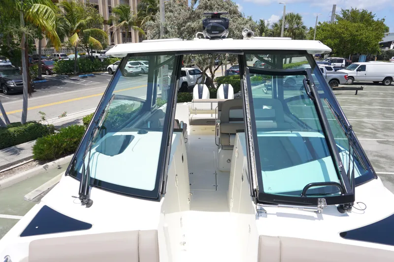 Slide: The Image of 2025 Boston Whaler 330 Vantage boat, docked with clear glass windshields and modern design. - 68