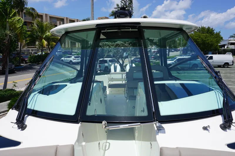 Slide: The Image of 2025 Boston Whaler 330 Vantage boat, docked with clear windshield view. - 69