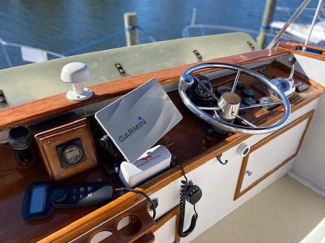 Slide: The Image of Vintage 1986 Wilbur 34 boat helm with Garmin navigation system and classic wooden dashboard. - 11