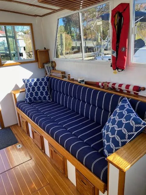Slide: The Image of 1986 Wilbur 34 boat interior with striped sofa, nautical pillows, and wooden flooring. - 15