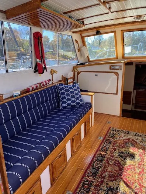Slide: The Image of Interior of 1986 Wilbur 34 boat with blue-striped seating and nautical decor. - 16