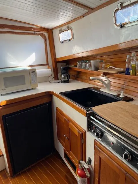 Slide: The Image of 1986 Wilbur 34 boat kitchen with microwave, sink, and stove. - 18