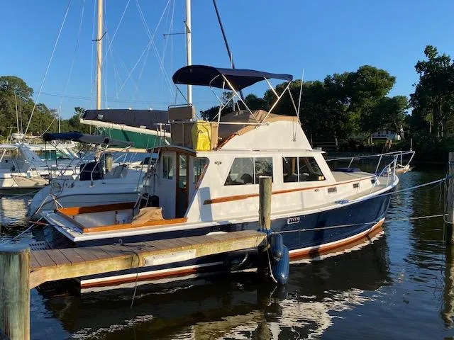 Slide: The Image of 1986 Wilbur 34 boat docked in a marina under clear blue skies. - 2