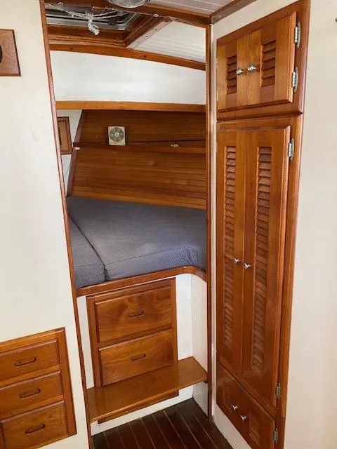 Slide: The Image of 1986 Wilbur 34 boat cabin with wooden interior and cozy bed. - 20