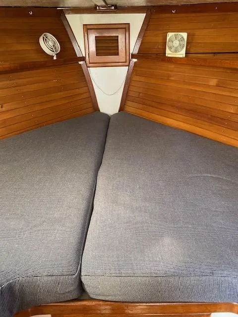 Slide: The Image of 1986 Wilbur 34 boat interior with wooden paneling and V-berth bed. - 21