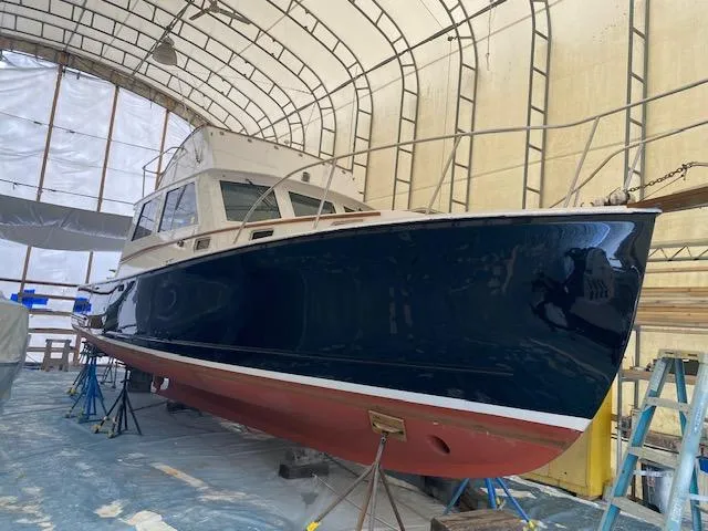 Slide: The Image of 1986 Wilbur 34 boat in a covered storage area, elevated on stands. - 24