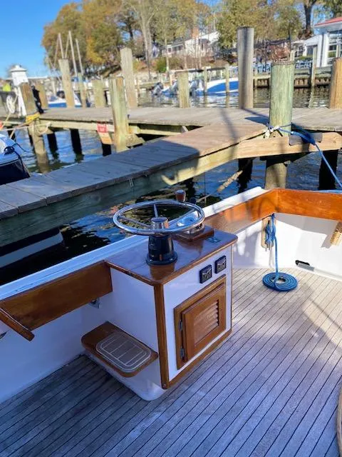 Slide: The Image of 1986 Wilbur 34 boat helm with wooden accents, docked at a marina. - 7