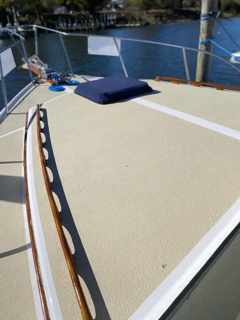 Slide: The Image of 1986 Wilbur 34 boat deck with wooden trim, docked by the water. - 8