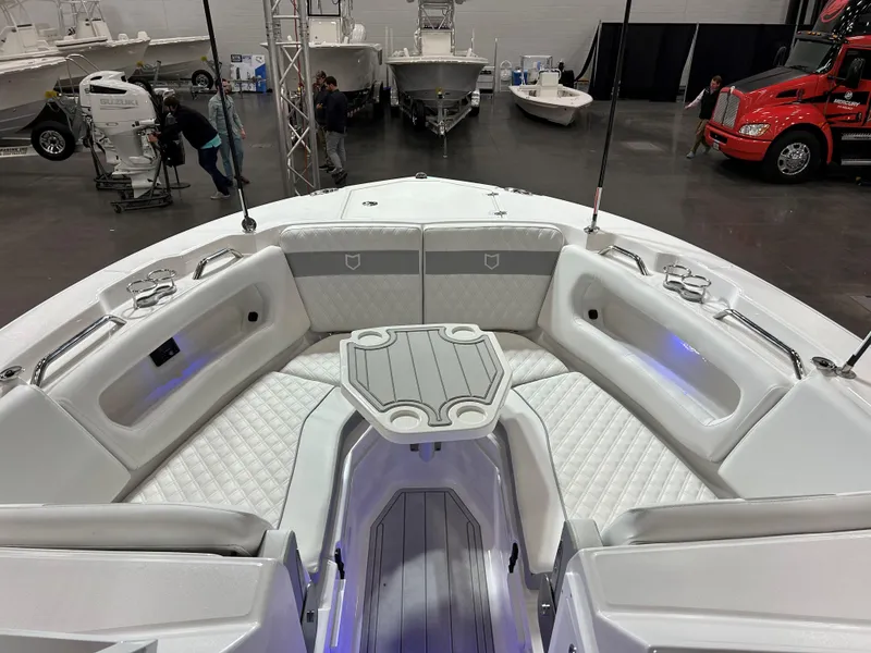Slide: The Image of 2025 Sea Fox 288 Traveler boat interior with seating and table at a boat show. - 2