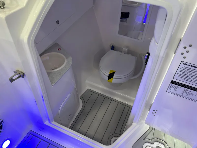 Slide: The Image of 2025 Sea Fox 288 Traveler boat bathroom with sink and toilet, featuring blue ambient lighting. - 4