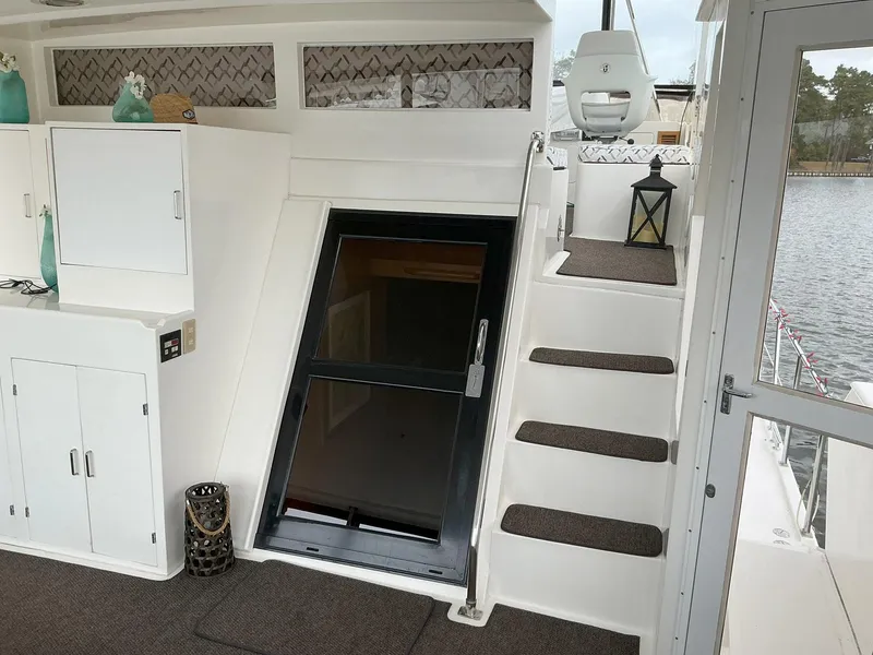 Slide: The Image of Novatec Islander 55 yacht interior, featuring stairs, cabinets, and decorative elements, 2000 model. - 12