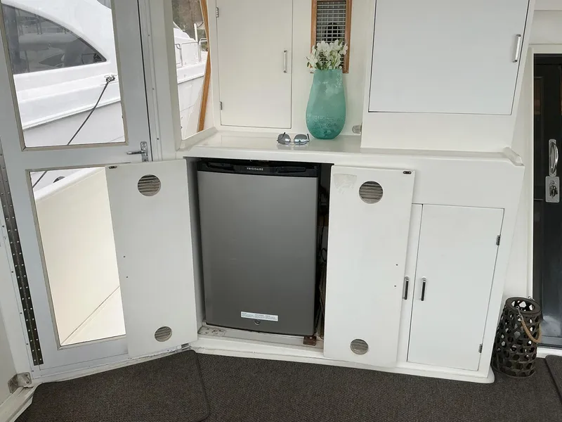 Slide: The Image of Novatec Islander 55 yacht interior with open cabinet and mini fridge, featuring modern decor. - 15