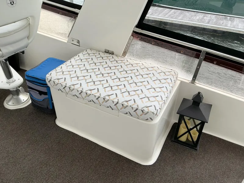 Slide: The Image of Cushioned seating area on 2000 Novatec Islander 55 yacht interior with lantern and cooler. - 22