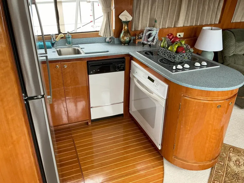 Slide: The Image of Kitchen area of 2000 Novatec Islander 55 yacht with modern appliances and wood finish. - 23
