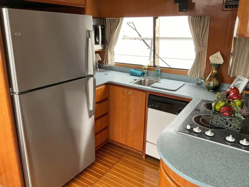 Slide: The Image of Novatec Islander 55 yacht kitchen, 2000 model, featuring modern appliances and wooden cabinetry. - 24