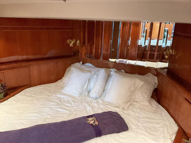 Slide: The Image of Luxurious bedroom interior of 2000 Novatec Islander 55 yacht with wooden paneling and plush bedding. - 35