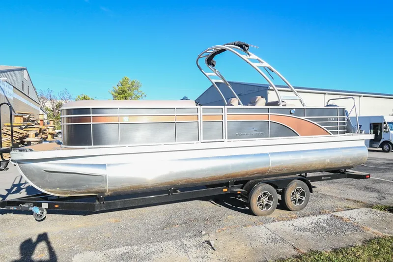 The Image of 2017 Bennington 23 GCW pontoon boat on trailer under clear blue sky. - 0