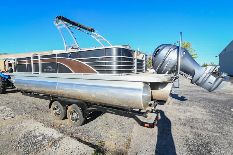 Slide: The Image of 2017 Bennington 23 GCW pontoon boat on trailer, parked outdoors. - 2