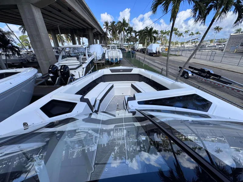 Slide: The Image of 2025 Cobalt R35 boat with sleek design, docked under a bridge, surrounded by palm trees. - 6