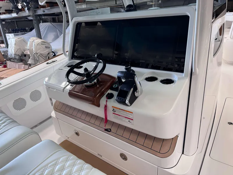 Slide: The Image of 2025 Phenom 37 CC boat helm with steering wheel and dual screens. - 14